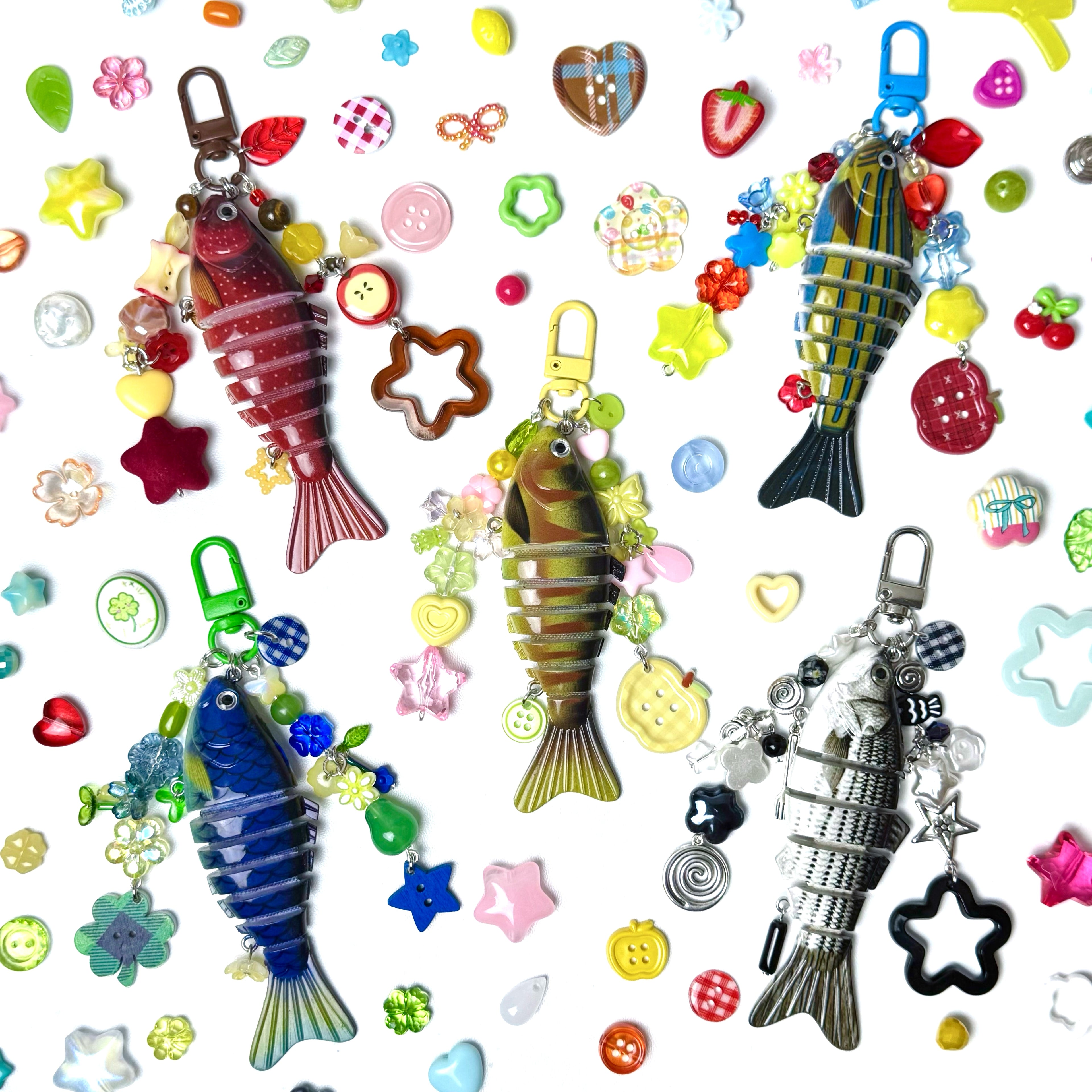 Colorful fish-shaped keychains with various charms on a patterned background