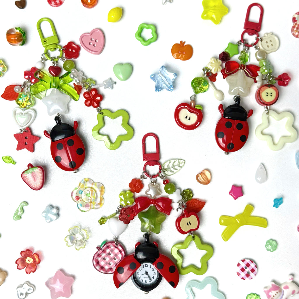 Colorful keychains with ladybugs, stars, and other shapes on a white background
