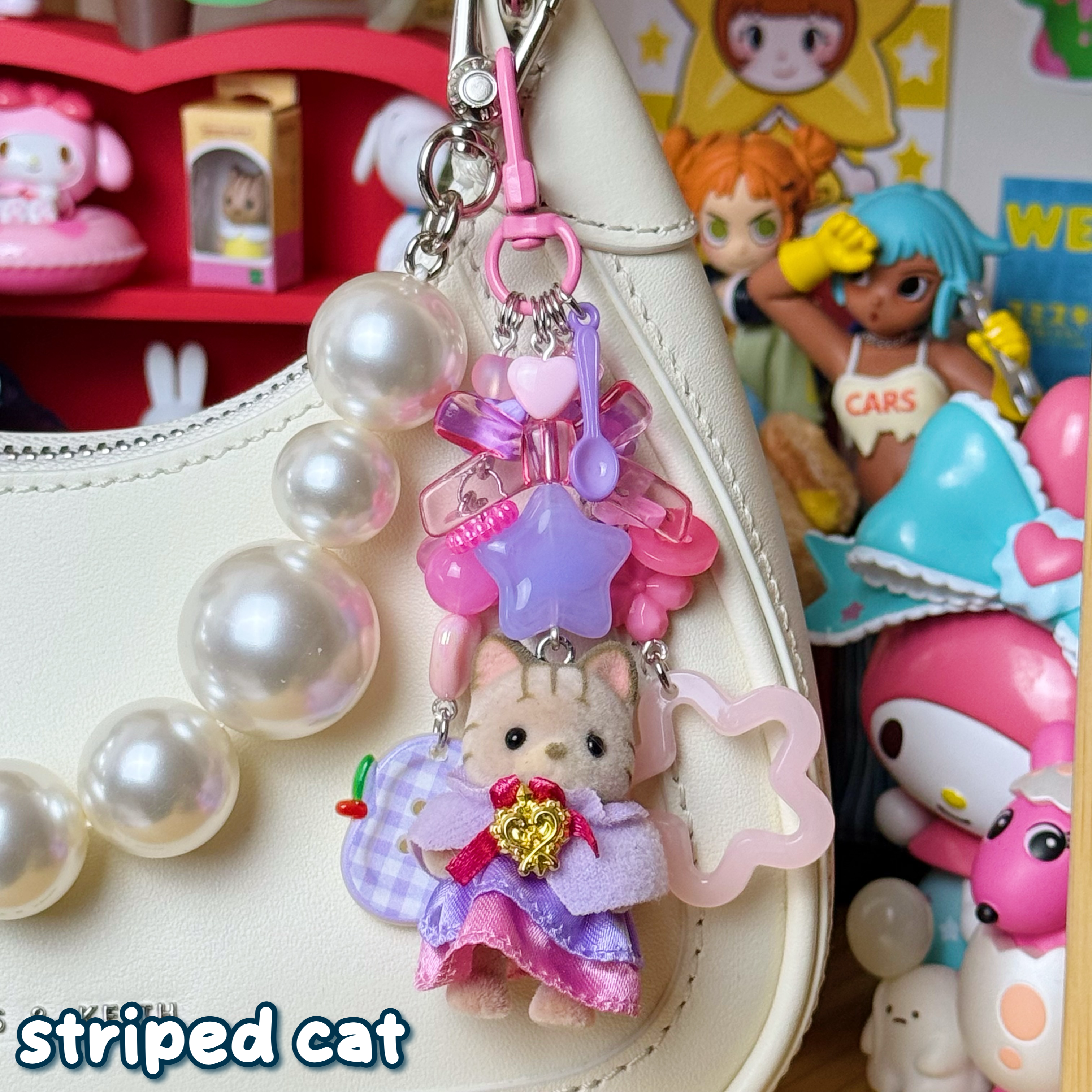 light pink, hot pink, & purple striped cat keychain; cat is wearing a princess outfit